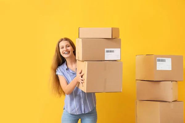 Jeune femme avec des boîtes en carton sur fond de couleur — Photo