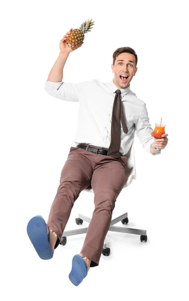 Glad revisor med ananas och cocktail sitter på stolen och drömmer om semester mot vit bakgrund — Stockfoto