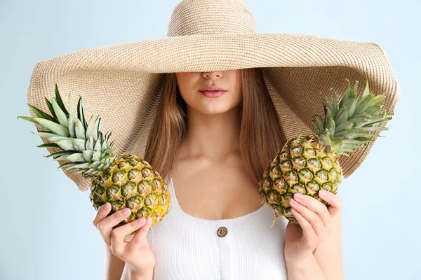 Mooie jonge vrouw met ananassen op witte achtergrond — Stockfoto