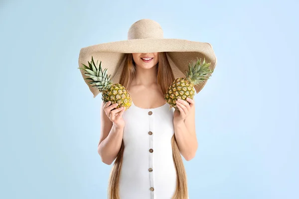 Mooie jonge vrouw met ananassen op witte achtergrond — Stockfoto