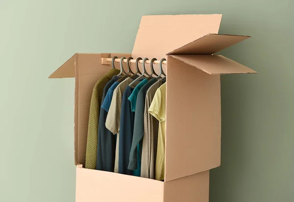 Wardrobe box with clothes near color wall