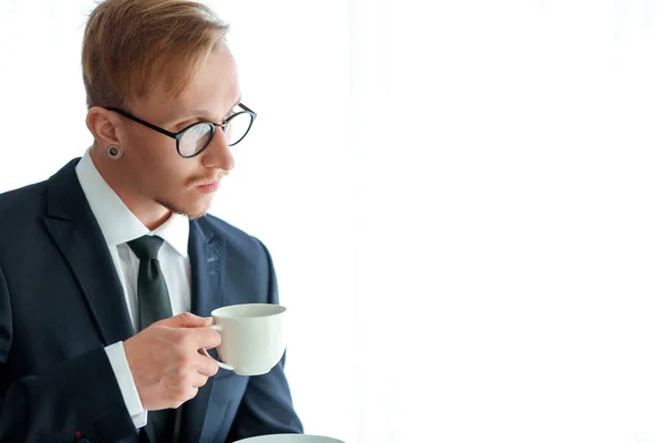 Hombre de negocios guapo bebiendo café cerca de la ventana — Foto de Stock