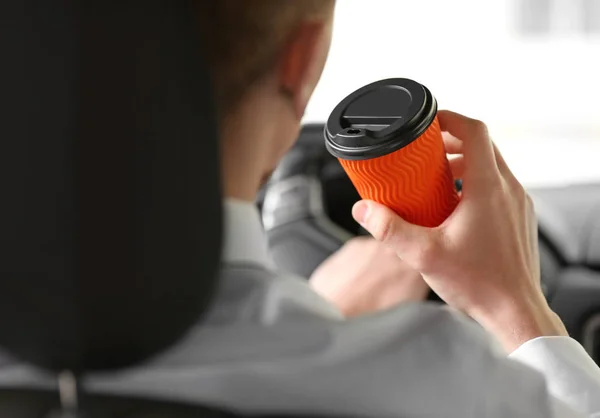 Handsome businessman drinking coffee in car — Stock Photo, Image