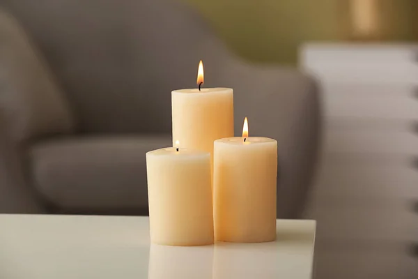 Belas velas acesas na mesa no quarto — Fotografia de Stock