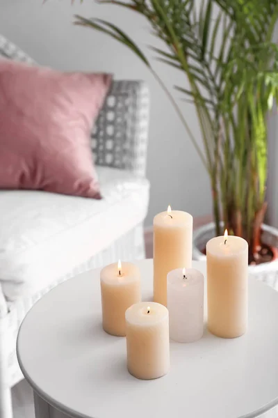 Krásné hořící svíčky na stole na pokoji — Stock fotografie