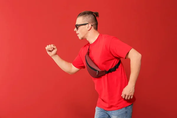 Handsome running young man on color background — Stock Photo, Image