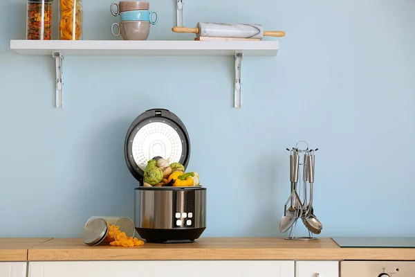 Multi cuisinière moderne avec légumes sur la table de cuisine — Photo