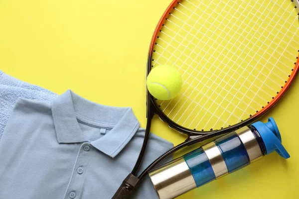 Tennisschläger, Kleidung, Wasserflasche und Ball auf farbigem Hintergrund — Stockfoto
