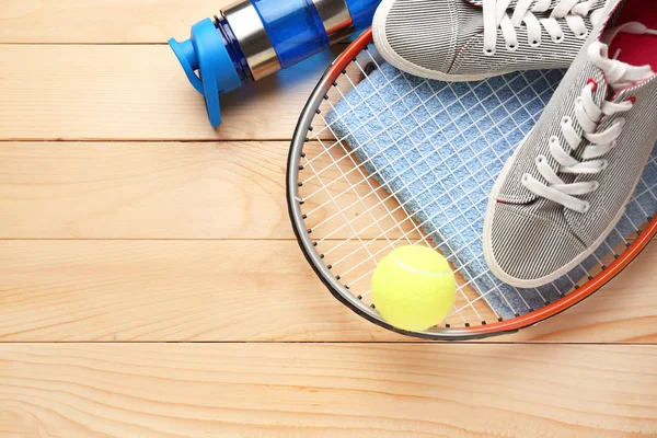 テニスラケット、靴、タオル、木製の背景に水とボールのボトル — ストック写真