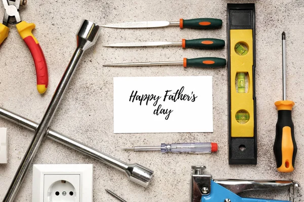 Diferentes herramientas y tarjetas con texto "Feliz Día del Padre" sobre fondo gris — Foto de Stock