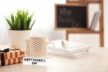 Bir fincan kahve, Babalar Günü için tebrik kartı ve masada hediye