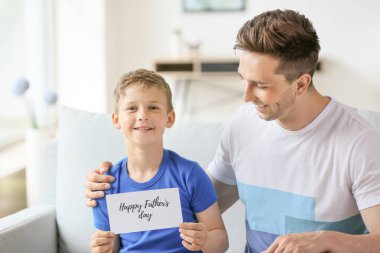 Küçük çocuk evde babasıyla birlikte Babalar Günü tebrik