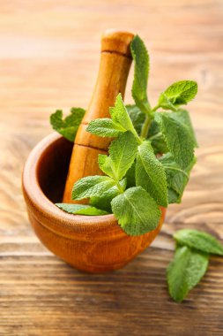 Ahşap arka plan üzerinde taze yeşil nane ve havaneli harç