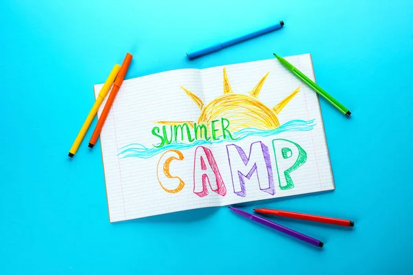 Copybook with drawing and text SUMMER CAMP on color background — Stock Photo, Image