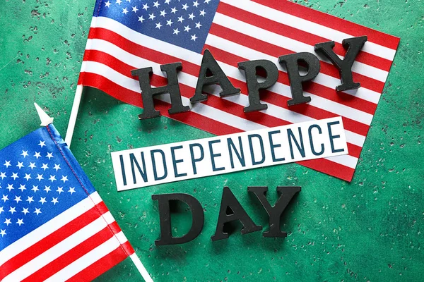 USA flags and text HAPPY INDEPENDENCE DAY on color background — Stock Photo, Image