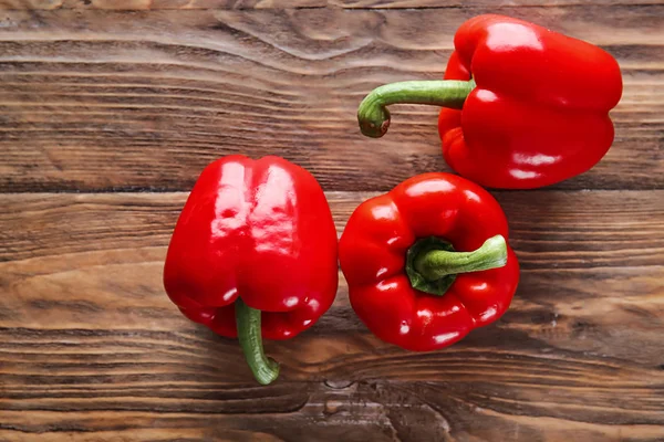 Pimientos rojos maduros sobre fondo de madera — Foto de Stock