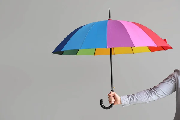 Mão feminina com guarda-chuva elegante no fundo cinza — Fotografia de Stock