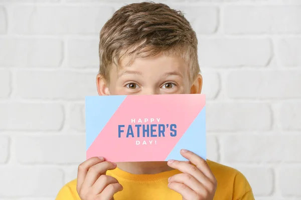 Menino segurando cartão de saudação para o Dia do Pai no fundo branco — Fotografia de Stock