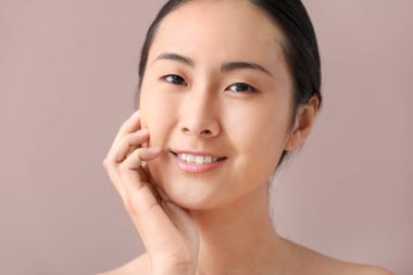 Renkli arka plan üzerinde makyaj uygulamadan önce Asyalı kadın