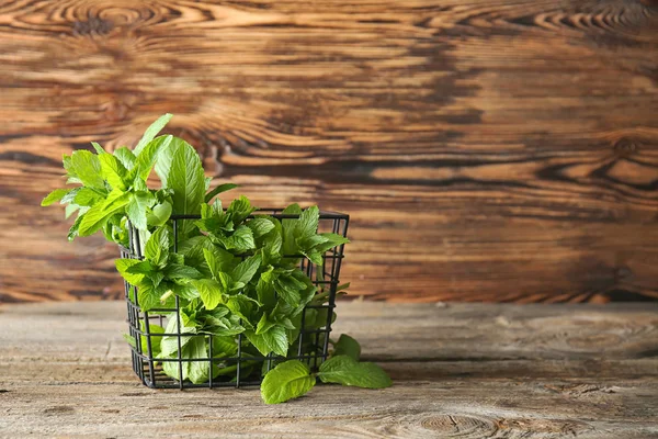 Korg med färsk mynta på trä bakgrund — Stockfoto