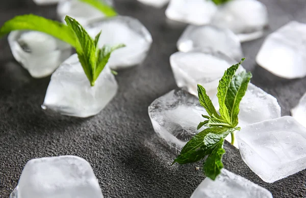 Ice cubes with green mint leaves on grunge background — Stock Photo, Image