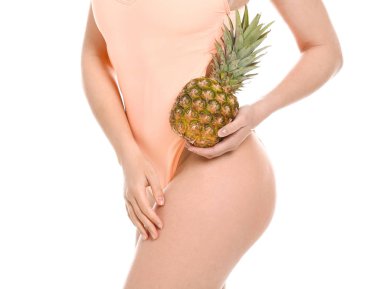 Yüzme takım elbiseli ve beyaz arka planda ananas ile güzel genç kadın