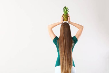 Beyaz arka planda ananas ile güzel genç kadın