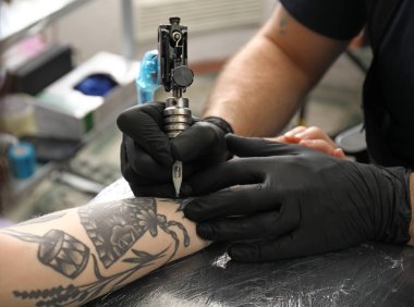 Profesyonel sanatçı kuaförde dövme yapıyor.