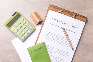 Vize başvuru formu, pasaport, damga ve hesap makinesi tabloda. Göç kavramı