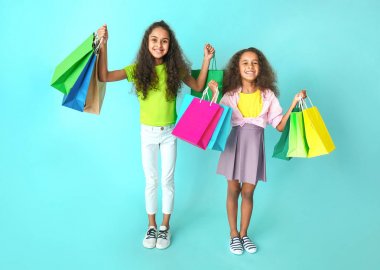 Renkli arka planda alışveriş çantaları ile Sevimli Afrikalı-Amerikalı kızlar