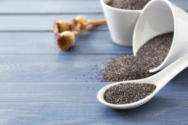 Tahta masa üzerinde haşhaş tohumu ile Kaşık ve kase