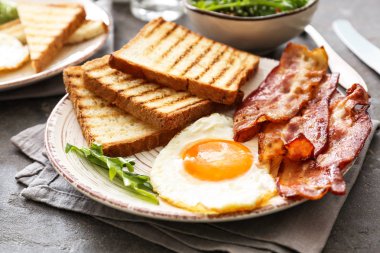 Masada lezzetli ızgara ekmek, kızarmış yumurta ve pastırma ile Tabak