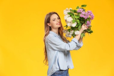 Renkli arka planda leylak çiçek buketi ile güzel genç kadın