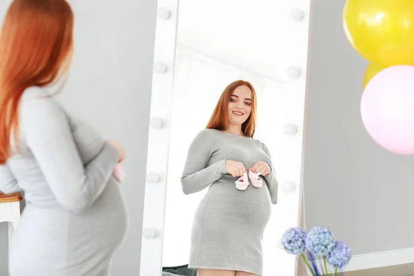 Beautiful pregnant woman looking in mirror at home — Stock Photo, Image