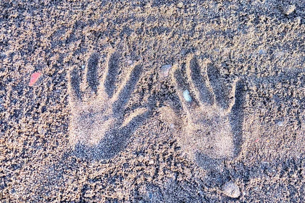 Human palm prints on beach sand