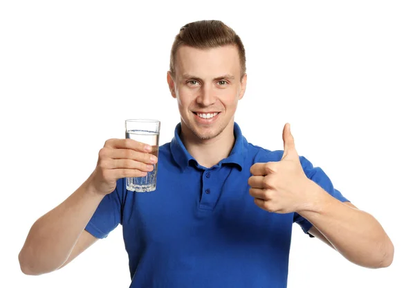 Bello giovane uomo con un bicchiere d'acqua che mostra pollice in su su su sfondo bianco — Foto Stock