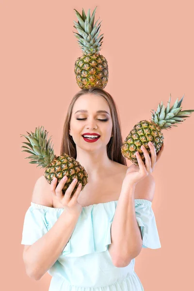 Piękna młoda kobieta z ananasów na kolorowym tle — Zdjęcie stockowe