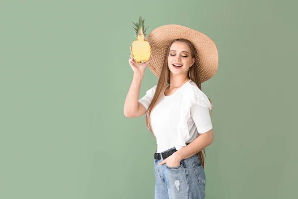 Mooie jonge vrouw met de helft van ananas op kleur achtergrond — Stockfoto