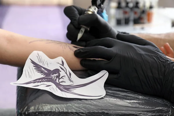 Professional artist making tattoo in salon — Stock Photo, Image