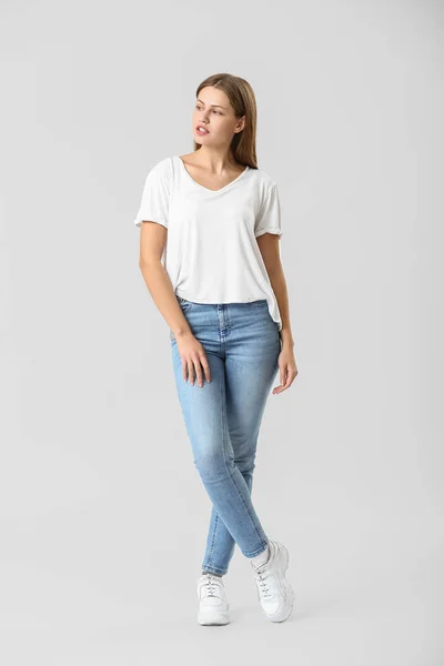 Krásná mladá žena v džínách na bílém pozadí — Stock fotografie