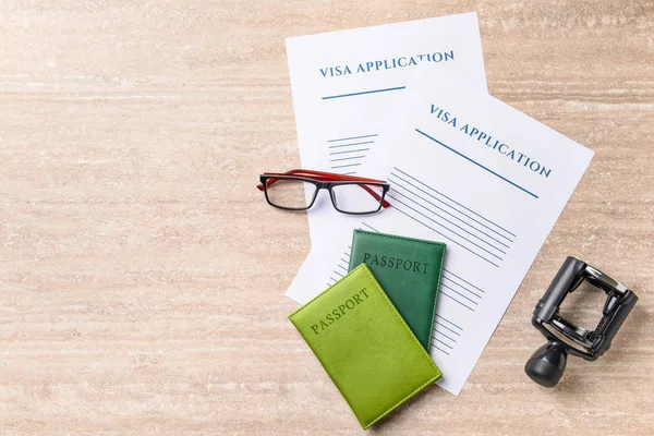 Formulários de solicitação de visto, passaportes, carimbo e óculos na mesa. Conceito de imigração — Fotografia de Stock