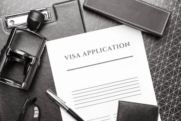 签证申请表、护照和桌上的印章。移民概念 — 图库照片