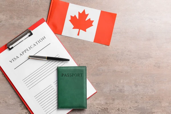Formulario de solicitud de visa, pasaporte y bandera canadiense en la mesa. Concepto de inmigración — Foto de Stock