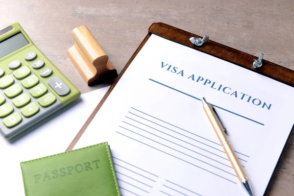 Vize başvuru formu, pasaport, damga ve hesap makinesi tabloda, closeup. Göç kavramı — Stok fotoğraf
