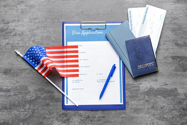 Visa application form, documents and USA flag on table. Concept of immigration