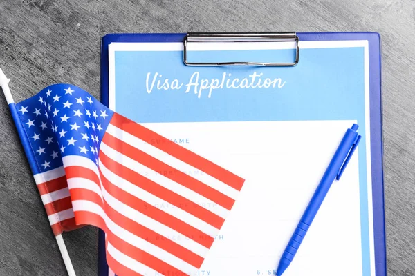 Visa application form and USA flag on table. Concept of immigration