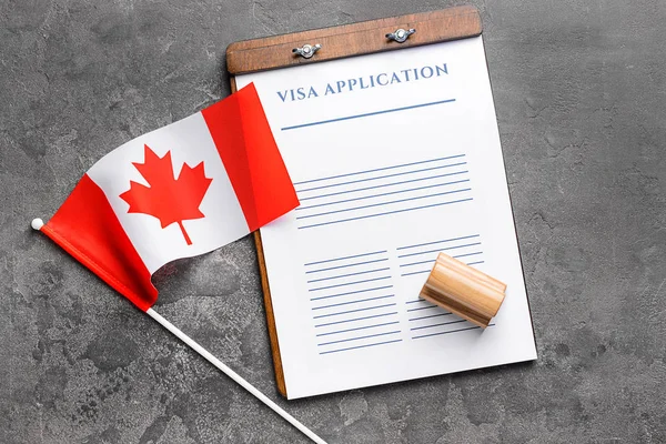 Formulario de solicitud de visado, sello y bandera canadiense en la mesa. Concepto de inmigración — Foto de Stock