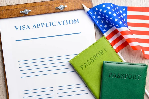 Formulário de pedido de visto, passaportes e bandeira dos EUA na mesa. Conceito de imigração — Fotografia de Stock