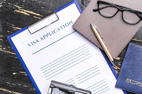 Visum aanvraagformulier, paspoort en stempel op tafel. Concept immigratie — Stockfoto