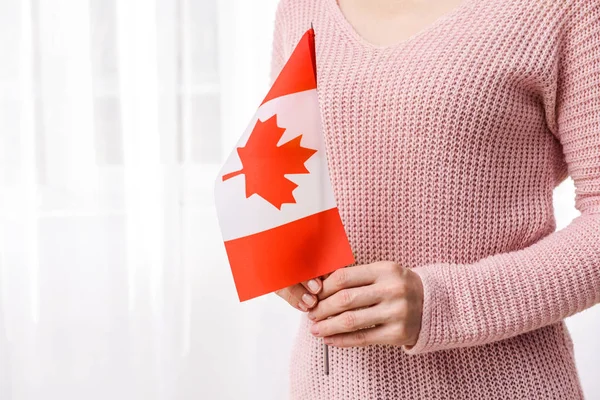 室内悬挂加拿大国旗的妇女 — 图库照片